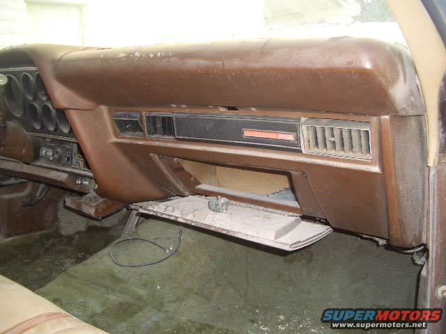 Brown dashboard with open glove compartment and air vents
