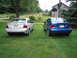 2005 Ford Focus - Two Ford Focus sedans are parked on a grassy area in front of a barn.