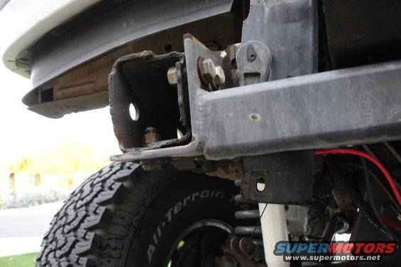 close-up of rusty bumper bracket and tire on a vehicle