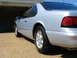 1995 Ford Thunderbird - Rear view of a silver 1995 Ford Thunderbird coupe parked in front of a garage.