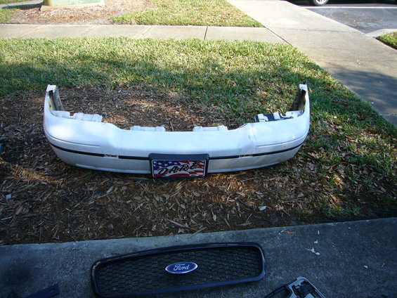 White Ford Crown Victoria front bumper with D.A.R.E. license plate frame and black Ford grille below