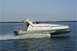 1978 Ford F-250 - A white catamaran boat with red and blue accents speeds across the water, leaving a foamy wake behind it.