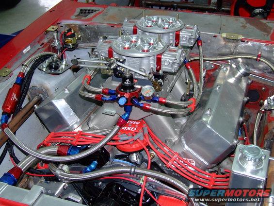 Engine bay with dual carburetors, red spark plug wires, and braided fuel lines. MSD ignition distributor visible