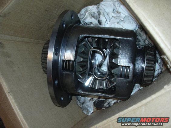 Differential assembly with visible gears and bearing, resting on cloth inside a cardboard box