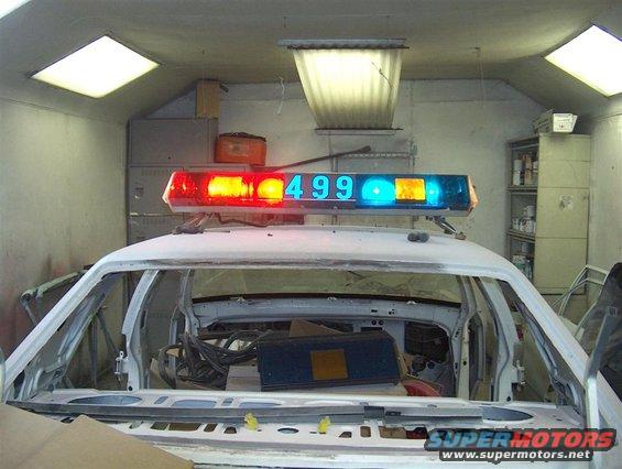 Police lightbar with "499" displayed on a white vehicle interior