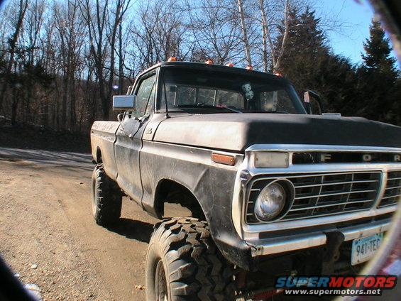 Lifted black Ford pickup truck, front end visible with grille and headlights. License plate reads 941-TEC