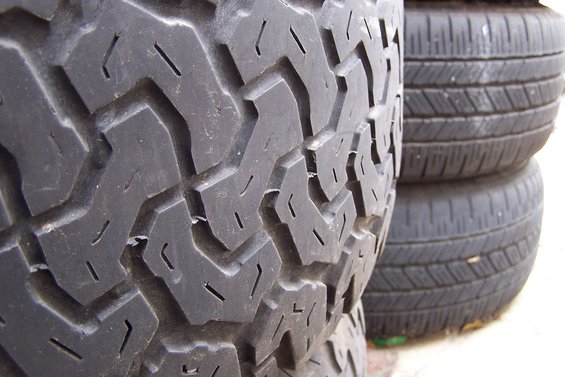 Close-up of tire tread pattern, with stacked tires in the background