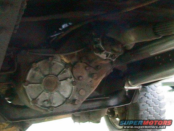 Transfer case underside of a truck, with visible text "SUPERMOTORS"