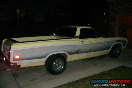 Yellow and grey Ford Ranchero with woodgrain-style side paneling, parked on a concrete driveway at night
