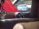 1994 Ford Probe - The interior of a car shows a chrome exhaust tip and red trim, with other vehicles seen through the rear window.