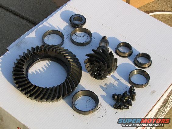 Differential gears, bearings, and bolts laid out on a white surface