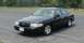 2001 Ford Crown Victoria - A black 2001 Ford Crown Victoria is shown from a three-quarter front view, parked on an asphalt surface with trees in the background.