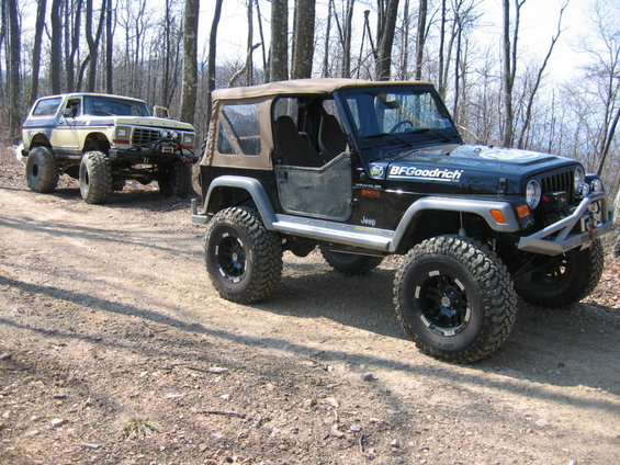 Jeep Wrangler and Ford Bronco on a dirt road in the woods
