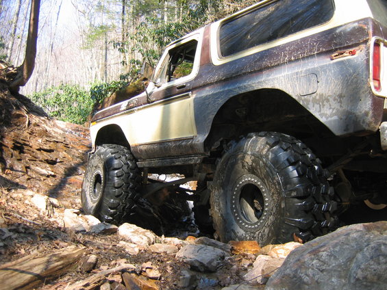 Brown and tan 1978 Ford Bronco off-roading on a rocky trail