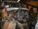 1978 Ford Bronco - A truck's engine bay is open with the engine suspended by a hoist, revealing the chassis and surrounding components.
