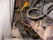 1978 Ford Bronco - This image shows a close-up view of an engine bay, focusing on the exhaust manifold and associated wiring, with some visible rust.