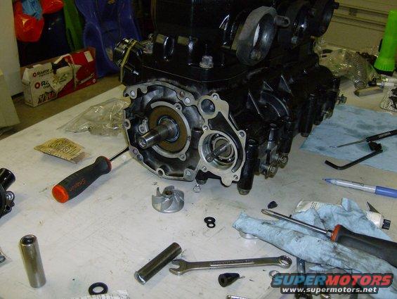 Engine block with internal components exposed, tools and rags on workbench