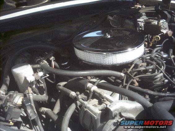 Engine bay of a 1985 Ford Crown Victoria LTD with a chrome air filter and visible hoses