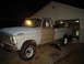 1967 Ford F-250 - A two-tone Ford F-250 pickup truck is parked outside a garage with its interior light on.