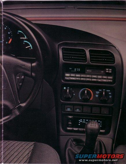 Car interior showing steering wheel, dashboard, radio, and gear shift