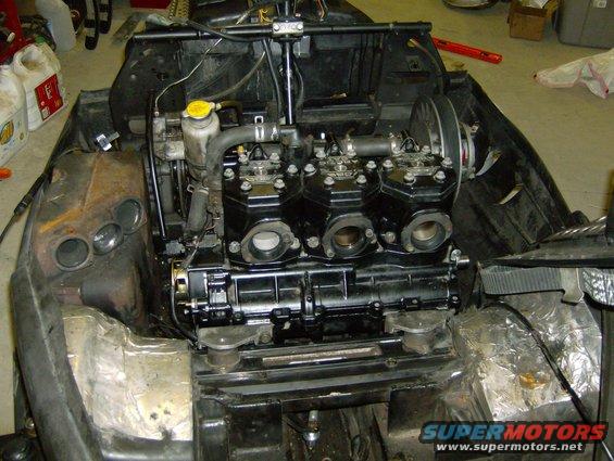 Snowmobile engine with three cylinders, exposed in a workshop