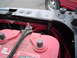 1989 Ford Bronco - Close-up of an engine bay a red Optima battery and red wiring conduit, with another vehicle visible in the background.