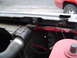 1989 Ford Bronco - Radiator support bracket and hose detail, with another vehicle visible in the background.