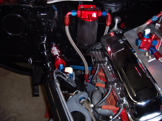 Engine bay with red fuel filter, chrome valve covers, and braided fuel lines