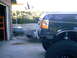 1989 Ford Bronco - The front bumper and fender of a dark-colored 1989 Ford Bronco are visible, with the headlight and wheel well in focus.
