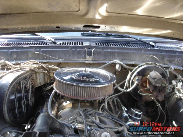 Engine bay with chrome air cleaner, brake master cylinder, and wiring. Hood is open