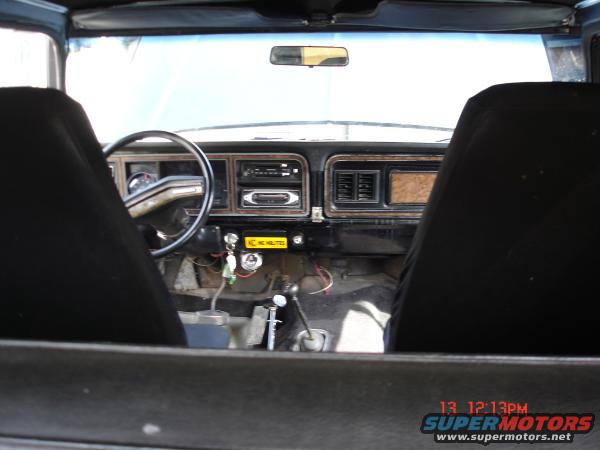1978 Ford Bronco interior with black seats, woodgrain dash trim, and a steering wheel
