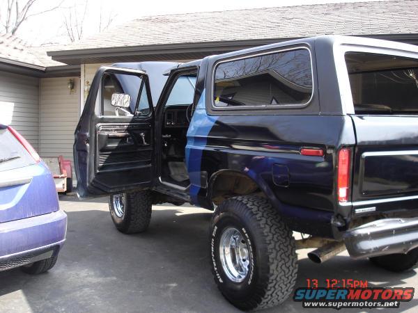 Black 1978 Ford Bronco with doors open, parked in driveway