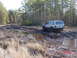 1995 Dodge 1500 - A silver Jeep Cherokee XJ tackles a challenging muddy off-road course, demonstrating its 4x4 capabilities.