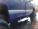 1995 Dodge 1500 - Mud-covered blue pickup truck with silver trim driving through shallow water.