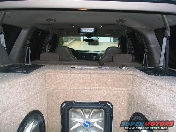 Interior view of a 2000 Ford Excursion with custom carpeted subwoofer box and speakers