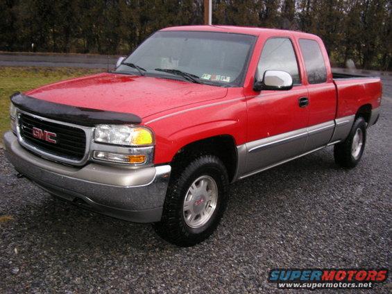 red GMC pickup truck with chrome trim and a bug deflector on the hood