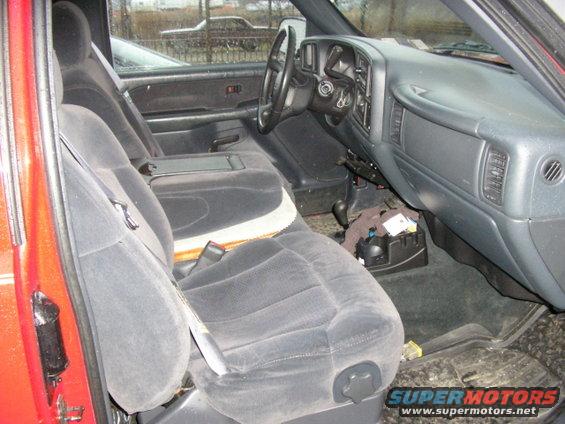 Interior view of a red truck, showing front seats, dashboard, and steering wheel