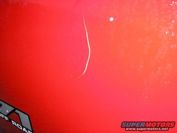 Red car body with a thin scratch and a partial graphic that says "OFF ROAD"