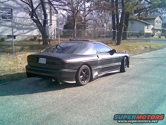 Dark gray 1993 Ford Probe parked on a residential street, rear 3/4 view