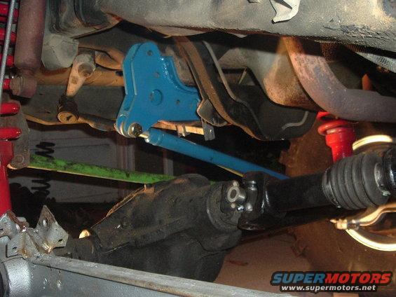 Blue suspension component and driveshaft on vehicle undercarriage