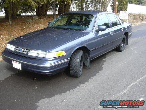 1996 Ford Crown Victoria parked on wet asphalt, front 3/4 view