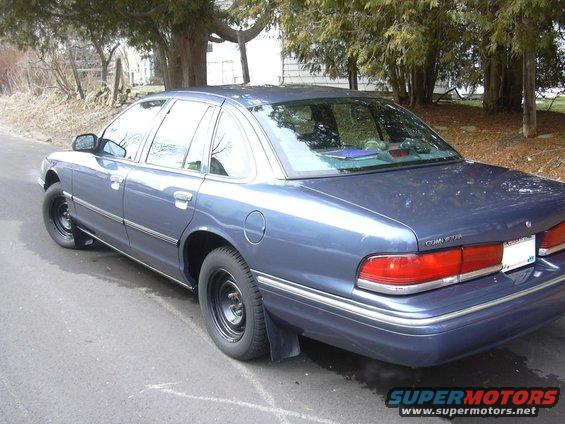 Blue 1996 Ford Crown Victoria parked on a street. Rear view shows taillights and 'Crown Victoria' badging