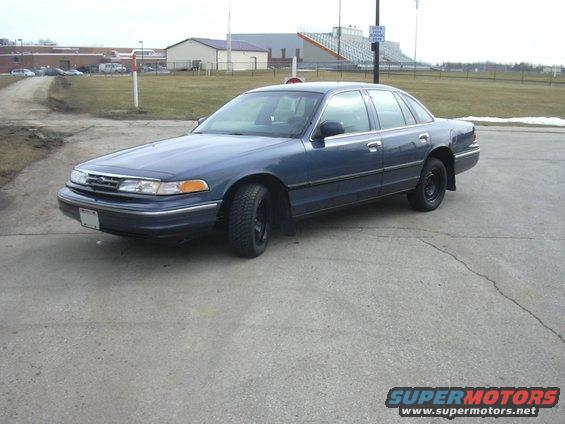 Blue sedan parked on asphalt, front quarter view. Black wheels, some snow on the ground