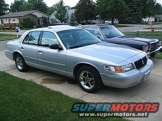 1999 Mercury Grand Marquis parked in driveway next to another car