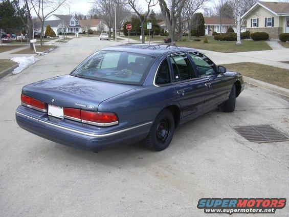 Blue sedan parked on a suburban street. It has a police-style rear end with a white license plate area
