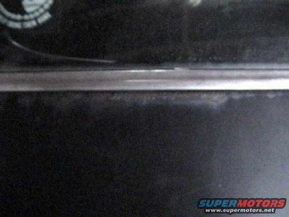 Black interior trim with a thin chrome strip and a partial circular emblem visible