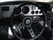 1977 Ford Mustang - The interior of a 1977 Ford Mustang II shows a silver dashboard with gauges and a three-spoke steering wheel.