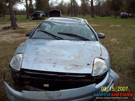 Light blue sedan with a cracked windshield and damaged front bumper, covered in dirt