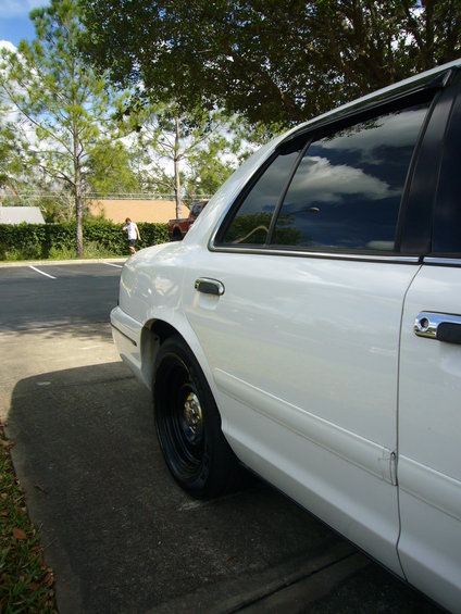 White 2000 Ford Crown Victoria side view, showing rear door and wheel