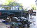 1974 Ford F-100 - A dark green pickup truck is shown lifted on jacks with its rear axle removed, suggesting ongoing maintenance or modification.